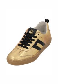 Sneaker dorato con texture e accenti neri, dotato di un logo rotondo nero e una suola in gomma.