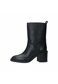 Botte de cheville en cuir noir avec une silhouette élégante, un orteil arrondi et un petit talon carré. Elle est dotée d'une languette à l'arrière pour un enfilage facile.