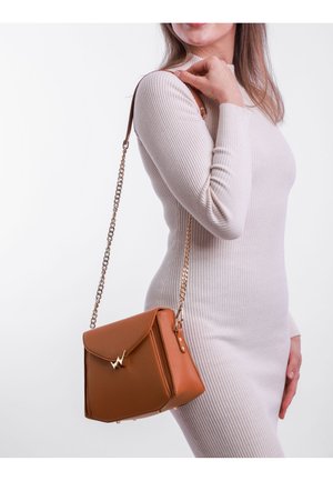 Brown leather handbag with a structured design, gold hardware, and a folding flap. It features a chain strap and textured surface.