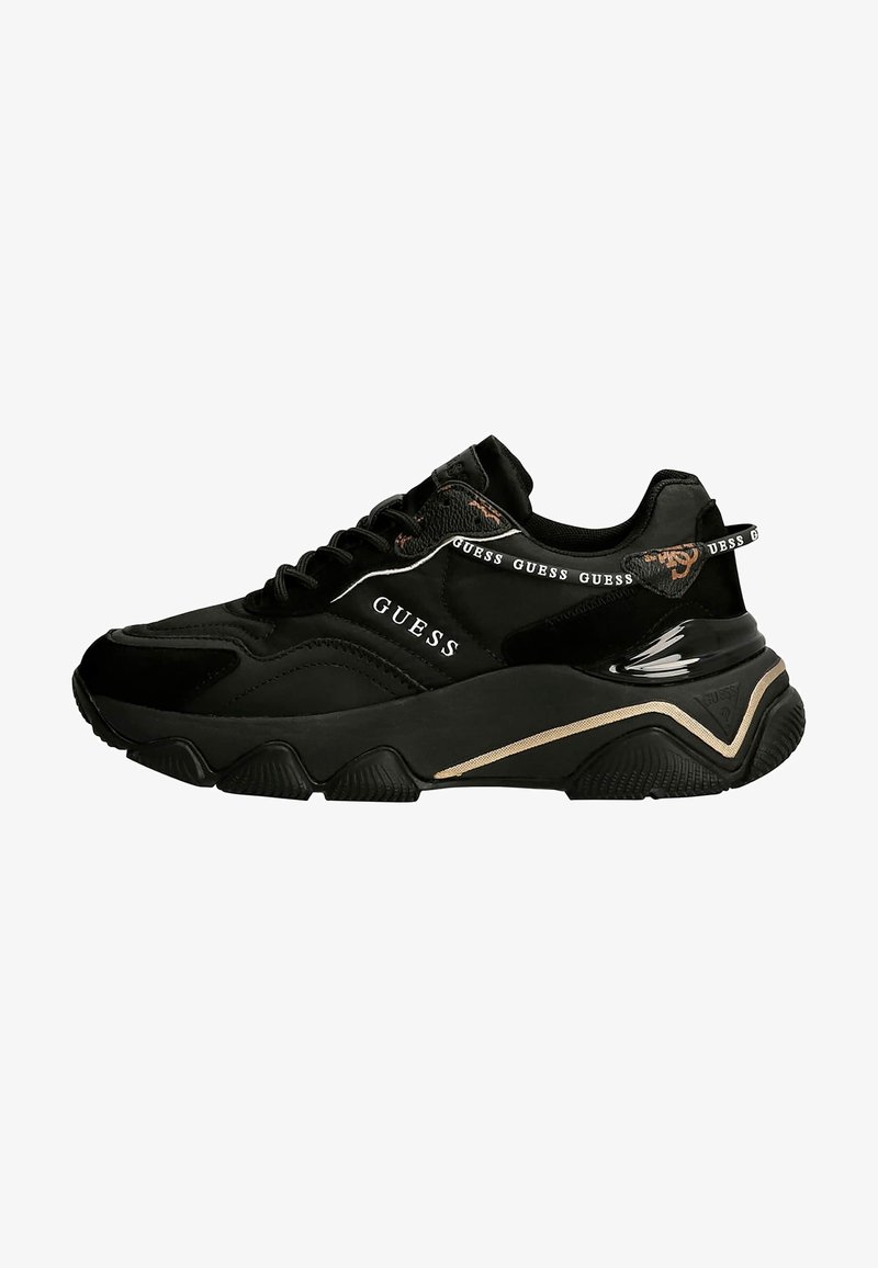 Sorte atletiske sneakers med en blanding af tekstureret ruskind og glat materiale, med et fremtrædende logo, sorte snørebånd og kontrasterende guld detaljer.