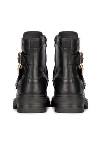 Bottines en cuir noir avec une finition texturée, des zips à l'arrière et des accents de boucle dorée sur le côté. Semelles en caoutchouc épaisses.