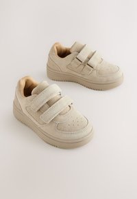 Beiget mokkanahkaiset tennarit, joissa on kaksoisvaljaat tarrakiinnityksellä, pyöristetty kärki ja kuvioitu kumipohja. Vähäiset rei'itykset, pehmeä sisäpinta.