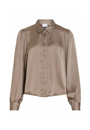 Brūna satīna krekls ar garām piedurknēm, apkakli, priekšā ar pogām un pūstām piedurknēm ar savilkumu. Gluda tekstūra ar klasisku piegriezumu.