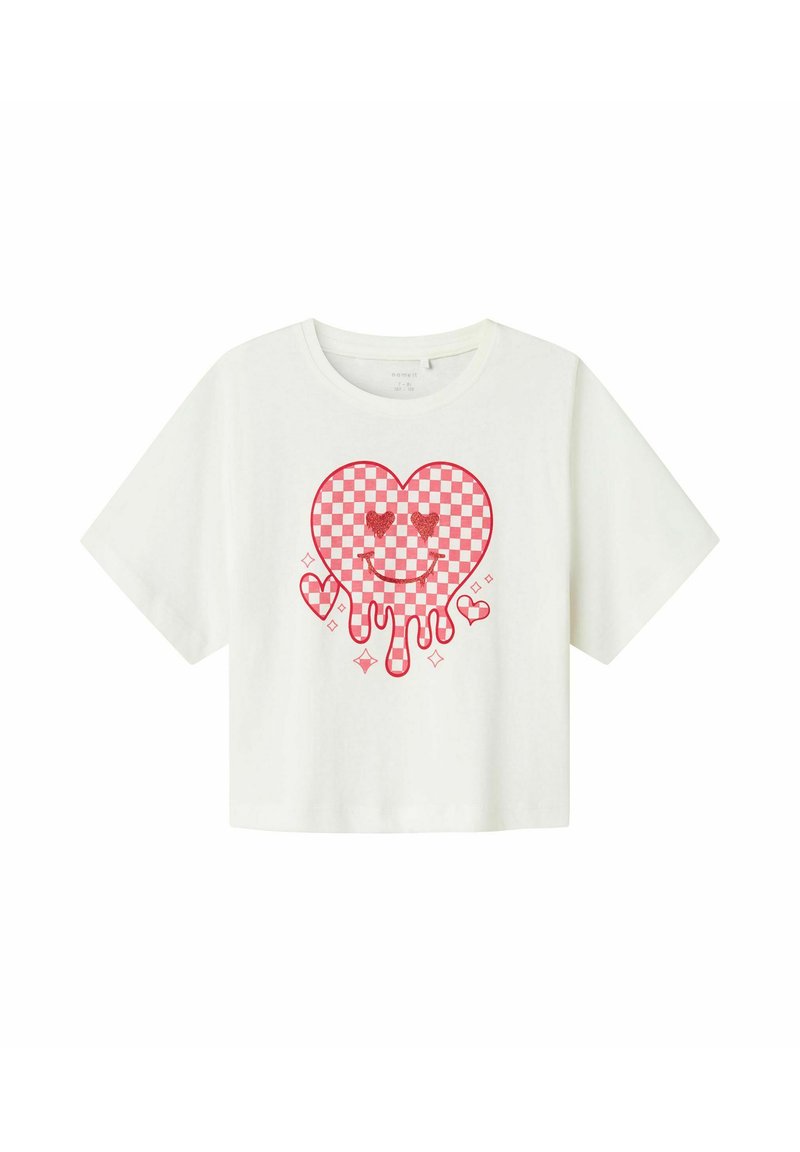 Camiseta corta blanca con un gráfico de corazón a cuadros rojos que incluye una cara sonriente, elementos que gotean y corazones más pequeños en un diseño contorneado.