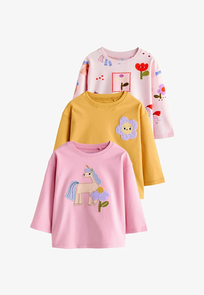 Trois t-shirts en coton à manches longues. En haut : rose clair avec des imprimés colorés. Au milieu : jaune avec un appliqué de fleur. En bas : rose avec un design de licorne.