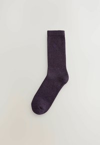 Lila gerippte Socke mit glatter Textur, die ein kleines Logodetail an der Seite hat. Entworfen für eine enge Passform und bequemen Tragekomfort.