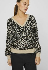 Sweter dzianiny o wzorze w czarno-beżowe zwierzęce cętki, z dekoltem w kształcie litery V, prążkowanymi mankietami i dołem, charakteryzujący się luźnym krojem.