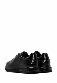 Zapatillas de cuero negro con un acabado brillante, con un diseño de cordones, un cuello acolchado y una suela texturizada para un mejor agarre.