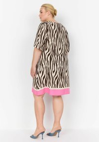 Beige-braun gestrektes Kleid mit pinkem Saum, kurzen Ärmeln und lockerer Passform. Hergestellt aus leichtem Stoff.
