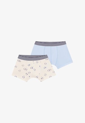 Deux paires de shorts pour garçons : un bleu clair uni et un crème avec un motif bleu de petits cercles. Les deux présentent des ceintures élastiques rayées.