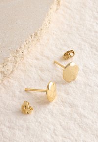 Goldene Ohrstecker mit strukturierter Oberfläche, rundem Design und glatter Oberfläche. Mit rundem Verschluss für sicheren Halt.