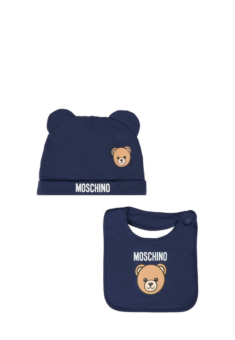 Beanie in cotone blu navy con orecchie da orso e logo; il bavaglino abbinato presenta una grafica di un orso e il logo; entrambi presentano una texture morbida e un design casual.