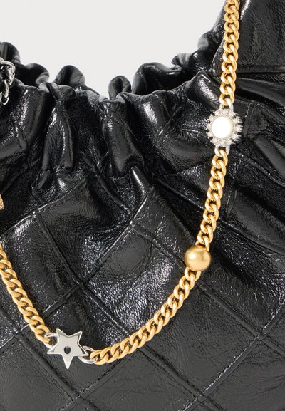 Musta tikattu käsilaukku, jossa on rypistetty yläosa ja kullanvärinen ketjusangassa on hopea- ja kultakoristeita, mukaan lukien tähti- ja pyöreitä koristeita.