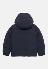 Jachetă puffer bleu marin cu glugă, având un design capitonat și manșete elastice. Textură netedă cu un aspect ușor, izolat.