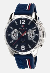 Orologio con cinturino in gomma blu, cassa in acciaio inossidabile silver, quadrante blu scuro, grandi numeri arabi, sottoquadranti e indicazioni tachimetriche.