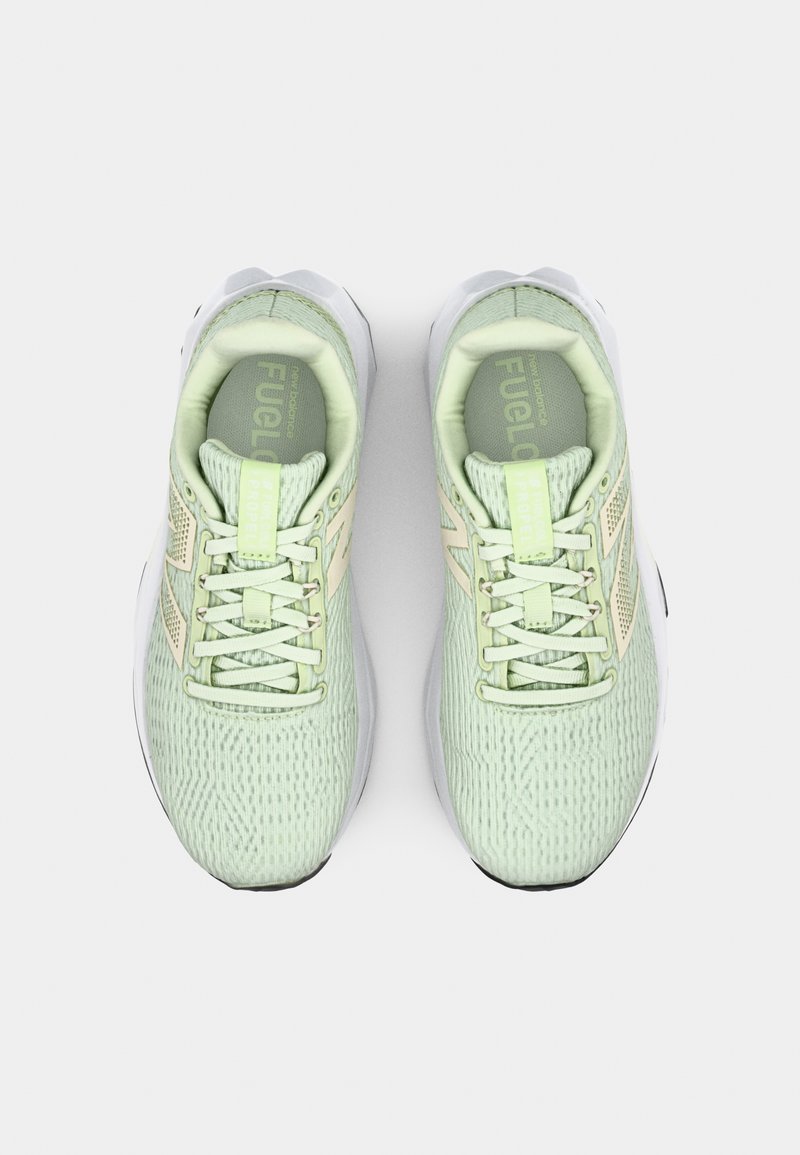 Chaussures de course vert clair avec une tige en maille texturée, des accents crème et des détails réfléchissants. Présente des lacets plats et une semelle rembourrée.
