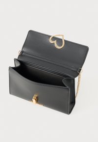 Clutch in pelle nera con una chiusura a forma di cuore dorata e tracolla a catena. Presenta un interno aperto con un compartimento e una texture liscia.