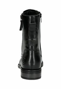 Botines de cuero negro con una textura suave, cierre de cremallera en la parte posterior y un tacón ligeramente elevado. Acentuados con un logotipo circular.