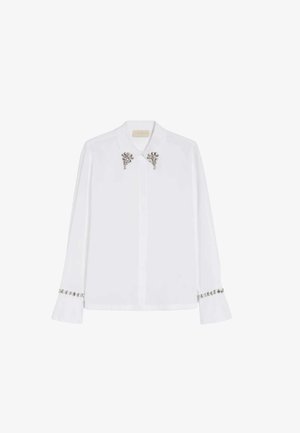 Camicia bianca a maniche lunghe con dettagli argentati decorativi su colletto e polsini, design classico con bottoni e tessuto liscio.