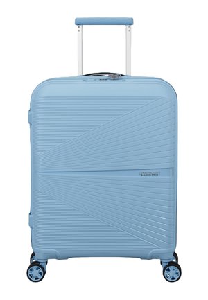 Valigia rigida azzurro chiaro con linee diagonali testurizzate, manico telescopico, quattro ruote girevoli e piccolo logo del marchio sul davanti.