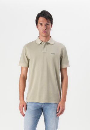 Licht olijfgroene polo shirt met korte mouwen, een omgeslagen kraag en een subtiele logo op de linkerborst. Gemaakt van gladde katoen stof.