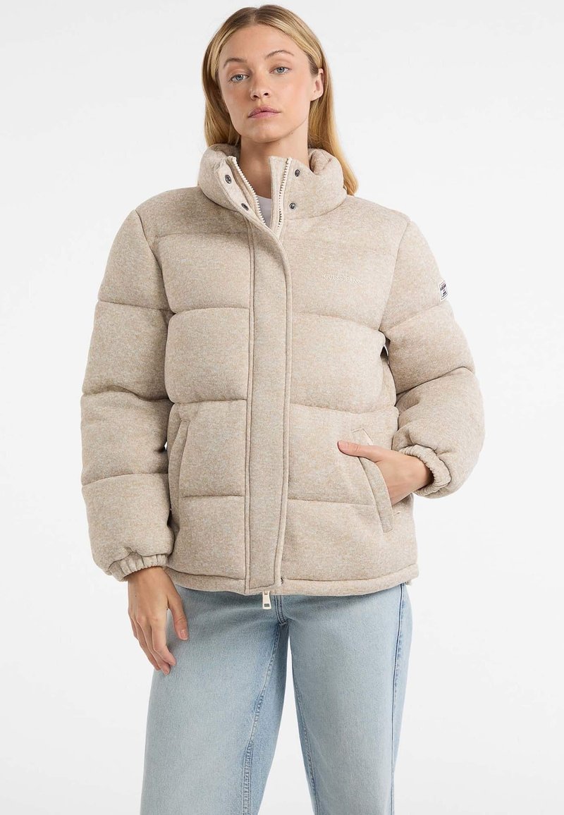 Geacă puffer bej cu guler înalt, manșete elastice, fermoar frontal, buzunare laterale și un finisaj moale texturat. Design ușor, cald și casual.