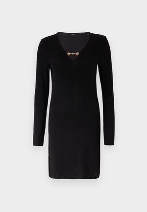 Črna dolga obleka z dolgimi rokavi in globokim V-izrezom, s kovinskim okrasnim zapenjanjem na izrezu. Gladka tekstura, prilegajoča se zasnova.