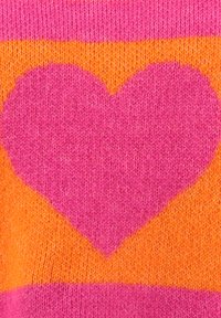 Rosa gestricktes Herzmuster auf einem orange-rosa gestrickten Stoffhintergrund.