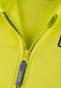 Bright yellow fleece jacket interior with a gray zipper. Features include a prominent zipper pull and a fabric tag with "SIGIKID" branding.