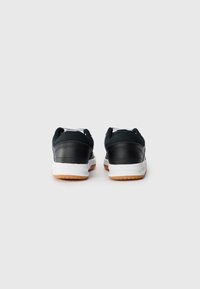 Svarte lær- og tekstilsneakers med hvite såler, som har en glatt tekstur og såle av gummikvalitet. Bakfra viser de design med polstret krage.