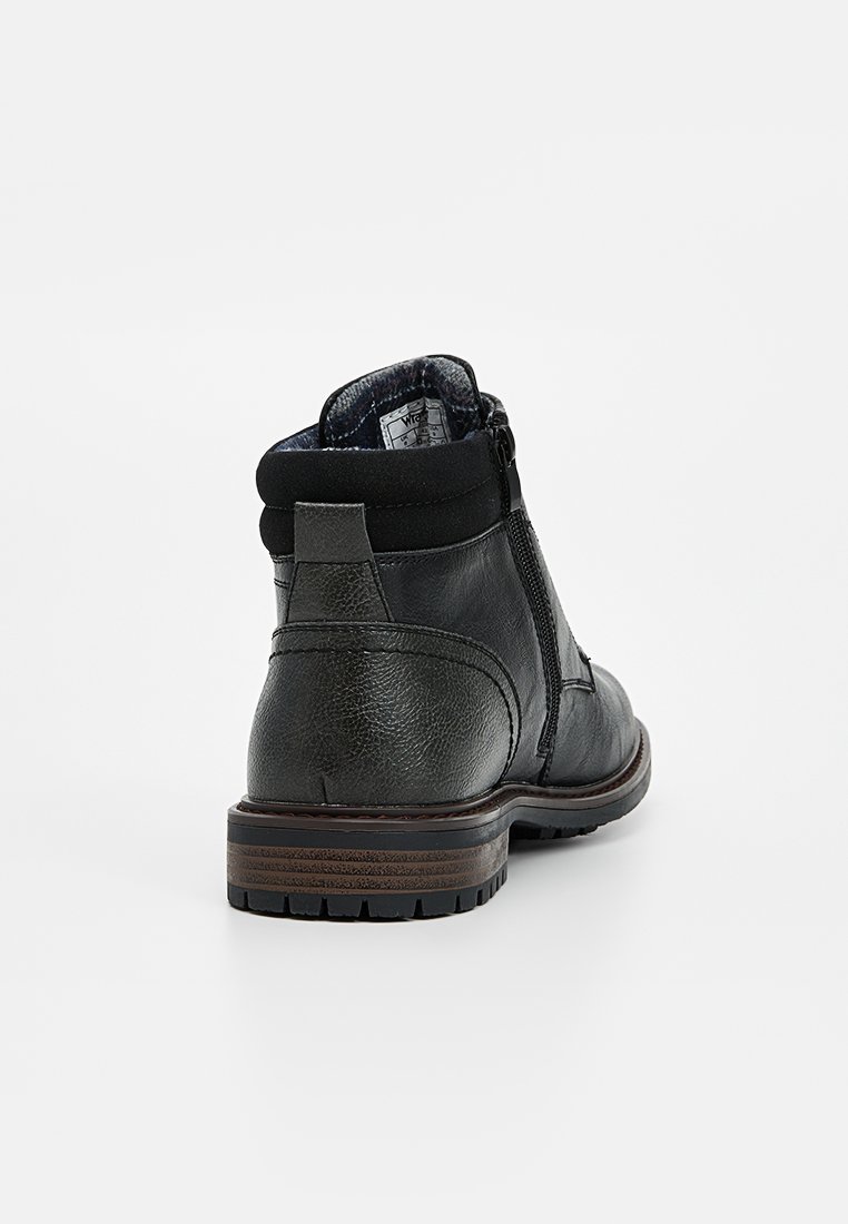 Botines de cuero negro con un acabado texturizado, cierre con cremallera lateral, panel elástico y suela de goma marrón.