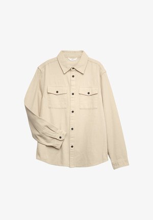 Béžová košile s dlouhým rukávem na knoflíky, se dvěma předními kapsami s klopou a černými knoflíky, položená natažená s mírně ohnutým levým rukávem.