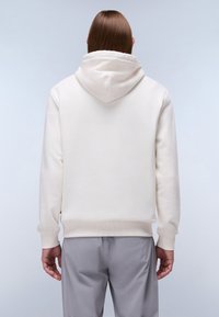 Sudadera blanca hecha de un material suave con capucha ajustable, puños y dobladillo acanalados, combinada con pantalones gris claro. Diseño sencillo y color neutro.