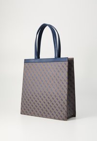 Sac fourre-tout en toile marron, orné d'un motif géométrique en bleu. Poignées et bordures en cuir, de forme rectangulaire structurée.