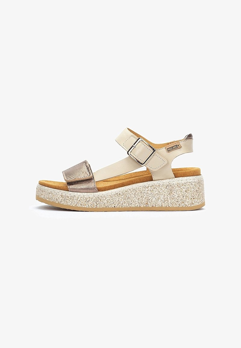 Sandale compensée beige avec semelle plateforme scintillante, bride à boucle argentée réglable et bride avant métallique, vue latérale sur fond blanc.