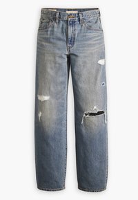 Jean en denim bleu avec jambes droites, fermeture par bouton et fermeture éclair, passants de ceinture, et plusieurs déchirures usées sur l'avant des cuisses et des genoux.