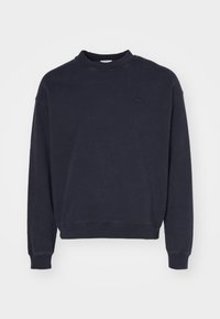 Námořnická crewneck mikina vyrobená z bavlněné směsi, s žebrovaným výstřihem a manžetami, s malým vyšitým logem na levé straně hrudi.