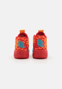 Punaiset tennarit, joissa on liekkikuosia, sinisiä yksityiskohtia, karhea kumipohja ja näkyvä takamerkintä. Ominaisuuksiin kuuluu pehmustettu nilkkakotelo ja kantapään lenkki.