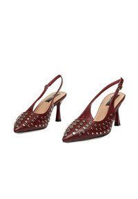 Tacones slingback de cuero burdeos con punta afilada, adornados con tachuelas plateadas, que cuentan con un tacón afilado y un forro interior suave.