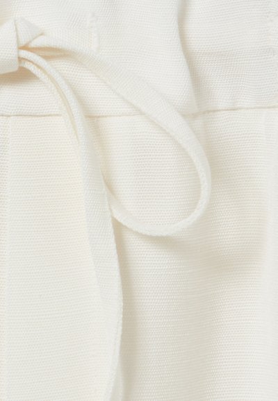 Tejido blanco con un entramado texturizado, acompañado de una corbata a juego. El material parece ligero y suave, adecuado para ropa casual.