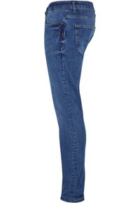 Jean en denim bleu slim-fit montré de profil avec poches avant et arrière visibles et taille avec passants de ceinture.