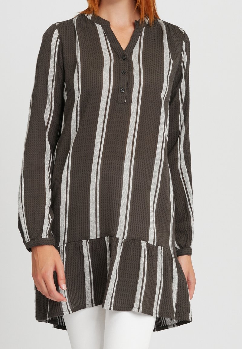 Brązowa i biała tunika w paski, lekkich materiałach, z długimi rękawami, dekoltem w szpic z guzikami oraz falowanym wykończeniem.