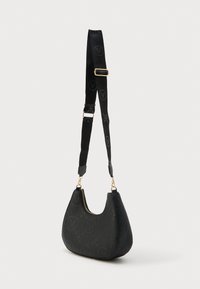 Bolso negro en forma de media luna con patrones circulares en relieve y correa ajustable de tela negra con herrajes dorados.