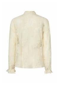 Langærmet cremefarvet bluse i blonder med blomsterprint, høj krave og flæsete manchetter, vist bagfra på en hvid baggrund.