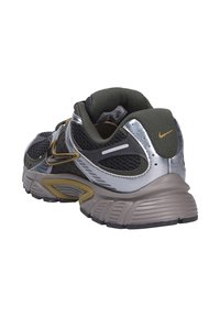 Sneakers Nike con una parte superiore in mesh grigia e argento, accenti verde oliva, suola in gomma testurizzata e dettagli riflettenti.