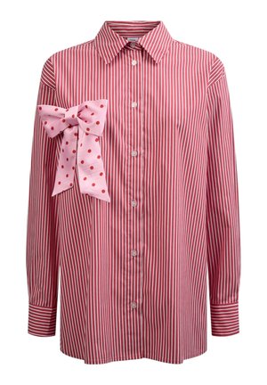 Chemise à manches longues rayée verticalement rouge et blanche avec col et boutons sur le devant, ornée d'un grand nœud rose à pois rouges sur la poitrine gauche.