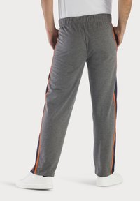 Graue Jogginghosen mit einem elastischen Bund, featuring orange- und marineblauen Seitenstreifen, lockerer Passform und einem weichen, strukturierten Stoff.