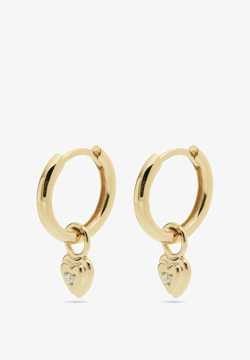 Orecchini a cerchio in oro con una finitura liscia e lucida, che presentano un piccolo charm a forma di cuore con una pietra trasparente attaccata sotto ogni cerchio.