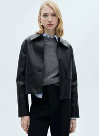Black leather cropped jacket with a pointed collar, front buttons, and two patch pockets; worn over a gray sweater and blue shirt.