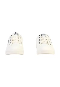 Zapatilla blanca con parte superior de cuero suave, puntera redonda y cordones planos; cuenta con detalles en negro y una marca en la lengüeta y el lateral.